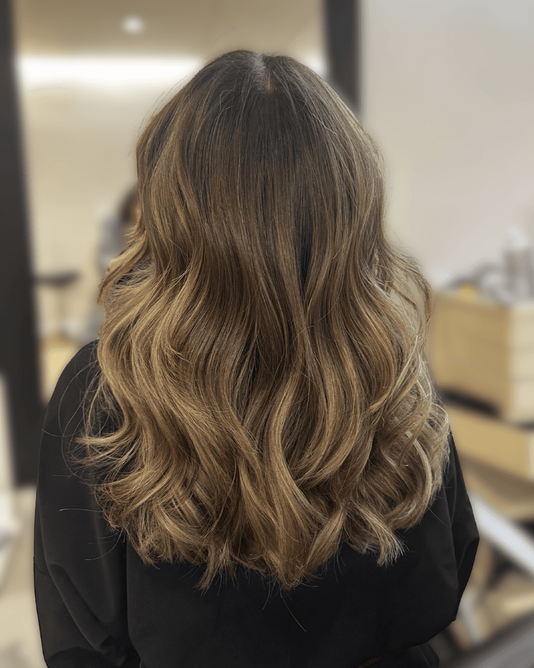 Soft lived-in brunette balayage with blended caramel highlights and natural movement. Low-maintenance dimensional color for an effortlessly luxurious look in NYC.